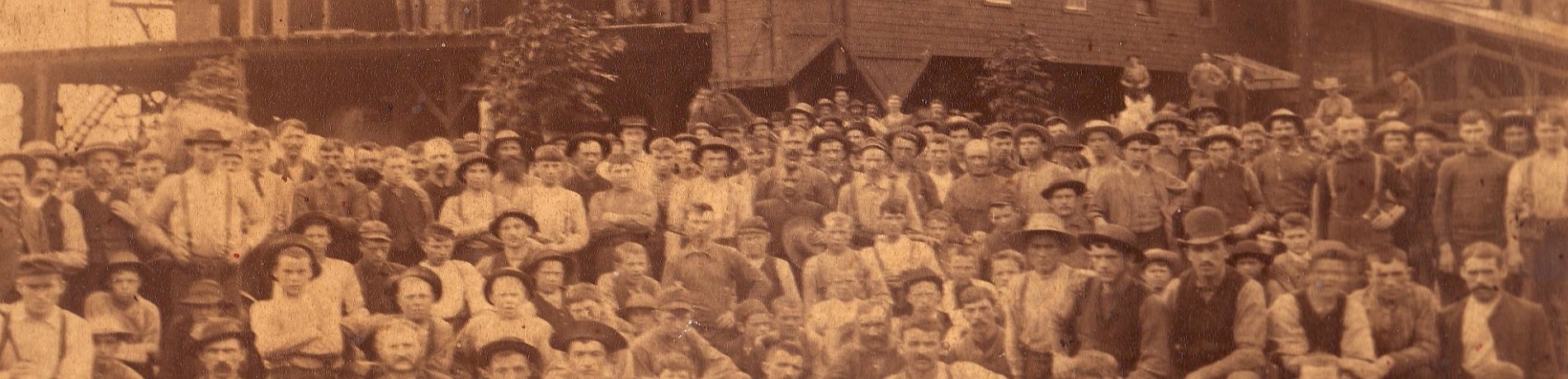 Group of people in front of a sawmill.